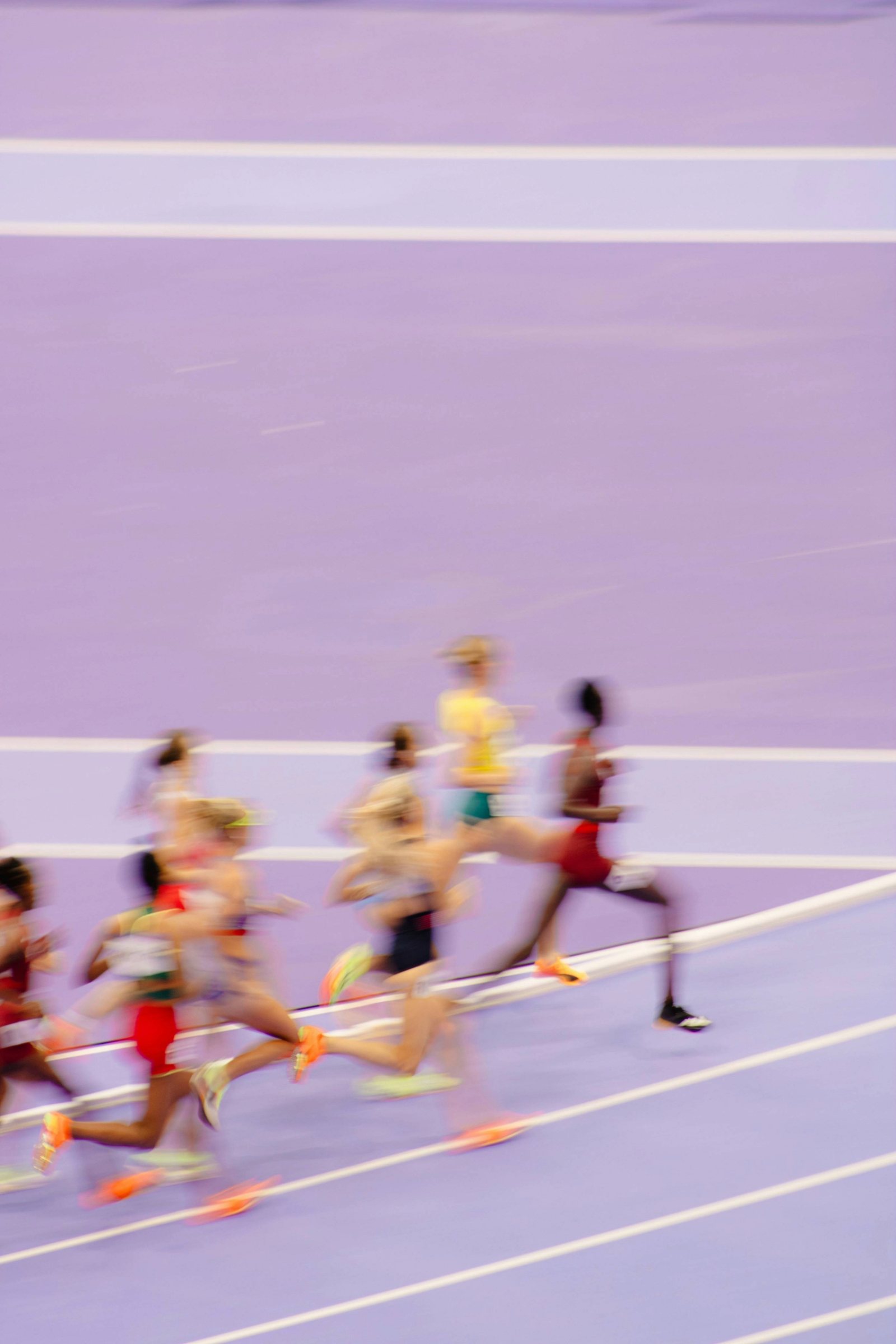 Runners rounding a bend on a purple track